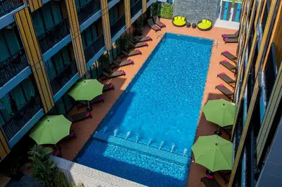 an overhead view of a swimming pool with chairs and umbrellas at GLOW Ao Nang Krabi in Ao Nang Beach