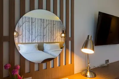 a room with a mirror with a bed and a lamp at GLOW Ao Nang Krabi in Ao Nang Beach