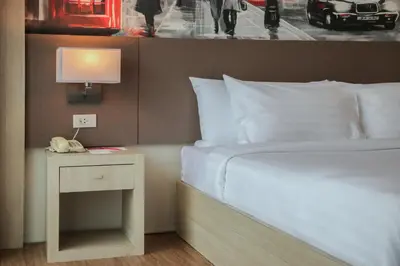 a bedroom with a bed and a nightstand with a lamp at GLOW Ao Nang Krabi in Ao Nang Beach