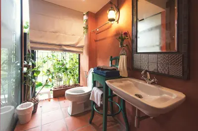 a bathroom with a sink and a toilet and a window at 2ROOMS Boutique House in Phuket Town