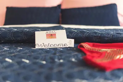 a close up of a bed with a welcome sign on it at 2ROOMS Boutique House in Phuket Town