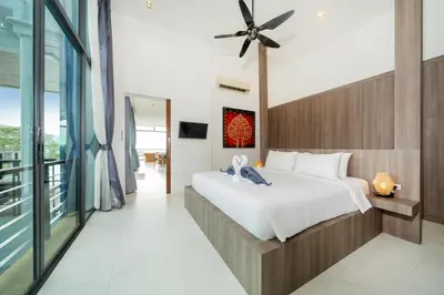 a bedroom with a large bed and a balcony at Kamala Sea View-villa with private pool and maid in Kamala Beach