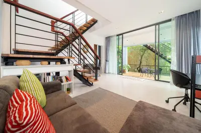 a living room with a couch and a staircase at Kamala Sea View-villa with private pool and maid in Kamala Beach