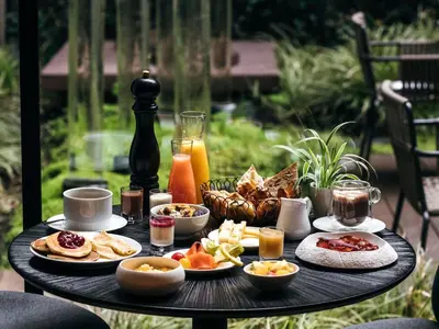 a table with breakfast foods and drinks on it at Navera Phuket - MGallery Collection in Surin Beach