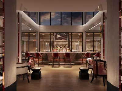 a restaurant with a bar with red chairs and windows at Navera Phuket - MGallery Collection in Surin Beach