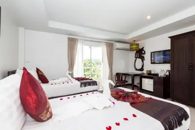 two beds with red pillows in a bedroom at Silver Resortel in Patong Beach