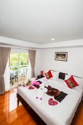 a bedroom with a large white bed with flowers on it at Silver Resortel in Patong Beach