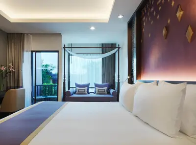 a bedroom with a large bed and a balcony at Chanalai Garden Resort, Kata Beach in Kata Beach
