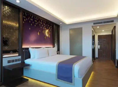 a bedroom with a large bed in a room at Chanalai Garden Resort, Kata Beach in Kata Beach