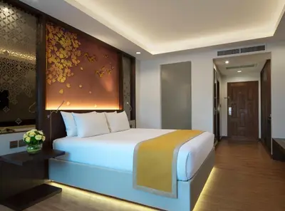 a bedroom with a large bed and a wall with flowers at Chanalai Garden Resort, Kata Beach in Kata Beach