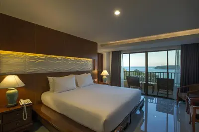 a bedroom with a large bed and a balcony at Chanalai Garden Resort, Kata Beach in Kata Beach