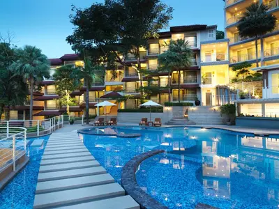 a hotel with a swimming pool in front of a building at Chanalai Flora Resort, Kata Beach in Kata Beach