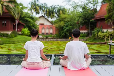 a man and a woman sitting on the floor practicing meditation at Ma Doo Bua Stay - SHA Extra Plus in Thalang