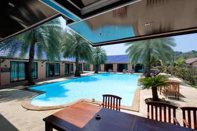 an indoor swimming pool with a table and chairs at MA MAISON BOUTIQUE HOTEL. in PHUKET in Bang Tao Beach