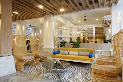 a lobby with a yellow couch and wicker chairs at Access Resort & Villas - SHA Plus in Karon Beach