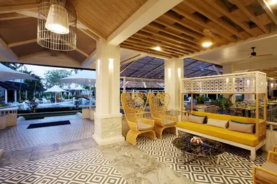 a living room with a yellow couch and chairs at Access Resort & Villas - SHA Plus in Karon Beach