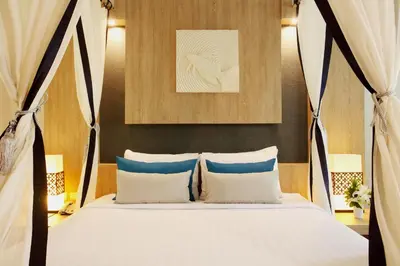 a bed with blue and white pillows in a room at Access Resort & Villas - SHA Plus in Karon Beach