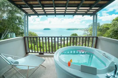 a tub on a balcony with a view of the water at Andaman Cannacia Resort & Spa - SHA Extra Plus in Kata Beach