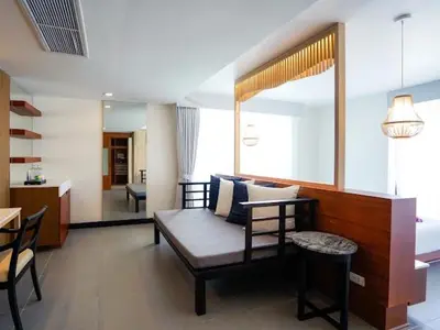 a living room with a couch and a table at Peach Blossom Resort & Pool Villa - SHA Plus in Kata Beach