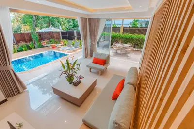 a living room with a couch and a pool at Peach Blossom Resort & Pool Villa - SHA Plus in Kata Beach