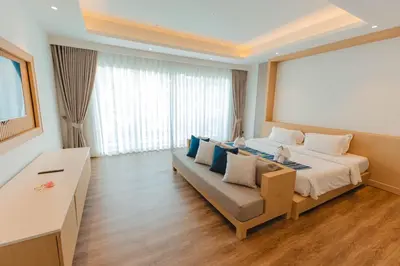 a hotel room with a bed and a couch at Peach Blossom Resort & Pool Villa - SHA Plus in Kata Beach