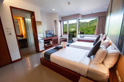 a bedroom with a large bed and a large window at Peach Blossom Resort & Pool Villa - SHA Plus in Kata Beach