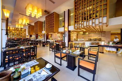 a restaurant with tables and chairs and a chef at Peach Blossom Resort & Pool Villa - SHA Plus in Kata Beach