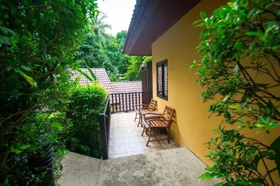 a balcony of a house with chairs on it at Peach Hill Resort - SHA Extra Plus in Kata Beach