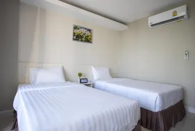 two beds in a room with white sheets at The Royal P Phuket - SHA Plus in Phuket Town