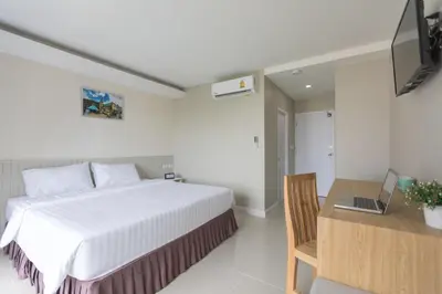 a bedroom with a bed and a desk with a laptop at The Royal P Phuket - SHA Plus in Phuket Town