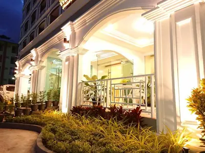 a white building with a balcony with plants at The Royal P Phuket - SHA Plus in Phuket Town