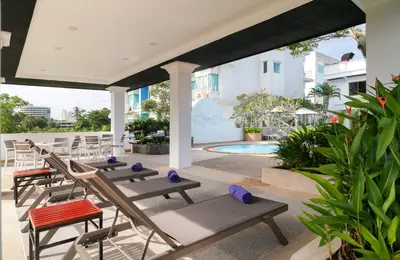 a patio with chairs and a swimming pool at The Old Phuket - Karon Beach Resort in Karon Beach