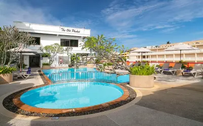 a swimming pool in front of a hotel at The Old Phuket - Karon Beach Resort in Karon Beach