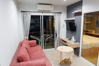 a living room with a pink couch and a bedroom at The Sea Condo Cozy Private Room at Ao nang Krabi in Ao Nang Beach