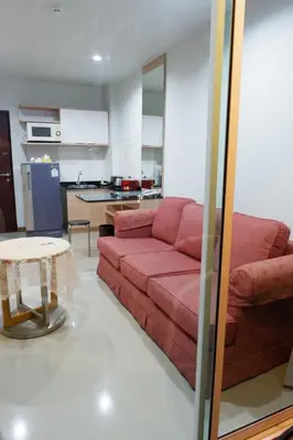 a living room with a red couch and a table at The Sea Condo Cozy Private Room at Ao nang Krabi in Ao Nang Beach