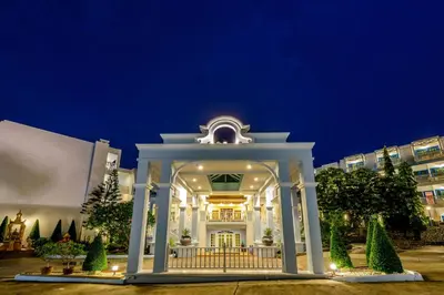 a white building with a gate at night at Andaman Seaview, Karon Beach - SHA Plus in Karon Beach