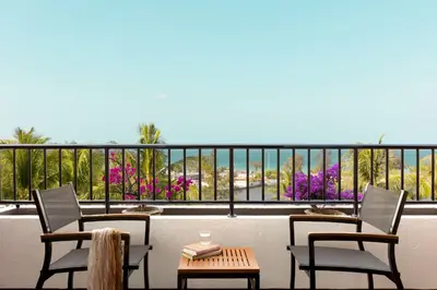 a balcony with two chairs and a table with a view at Best Western Phuket Ocean Resort in Karon Beach