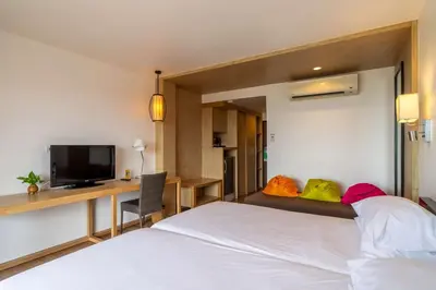 a bedroom with a bed and a desk and a tv at Best Western Phuket Ocean Resort in Karon Beach