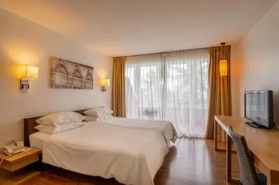 a hotel room with a bed and a television at Best Western Phuket Ocean Resort in Karon Beach