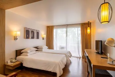 a hotel room with two beds and a desk at Best Western Phuket Ocean Resort in Karon Beach