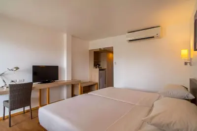 a bedroom with a bed and a desk and a television at Best Western Phuket Ocean Resort in Karon Beach