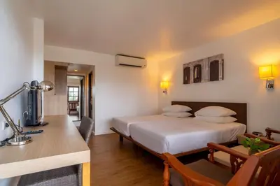 a hotel room with a bed and a desk with a desk at Best Western Phuket Ocean Resort in Karon Beach