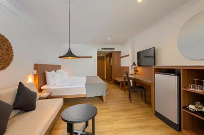 a hotel room with a bed and a dining room at Sunprime Kamala Beach in Kamala Beach