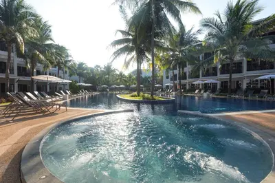 a swimming pool with palm trees in a resort at Sunwing Bangtao Beach in Bang Tao Beach
