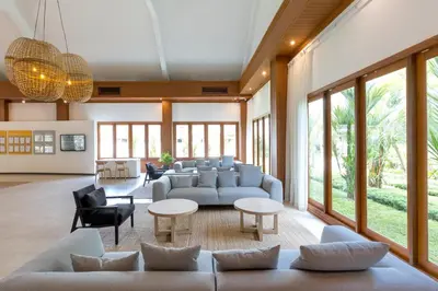 a living room with couches and tables and windows at Sunwing Bangtao Beach in Bang Tao Beach