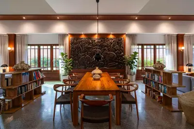 a library with a wooden table and chairs and bookshelves at Best Western Premier Bangtao Beach Resort & Spa in Bang Tao Beach