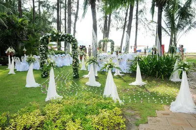 a row of tables with white chairs and flowers at Best Western Premier Bangtao Beach Resort & Spa in Bang Tao Beach