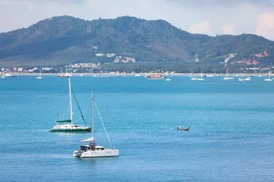 two boats floating on a large body of water at By The Sea in Panwa Beach
