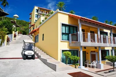 a golf cart parked outside of a building at By The Sea in Panwa Beach