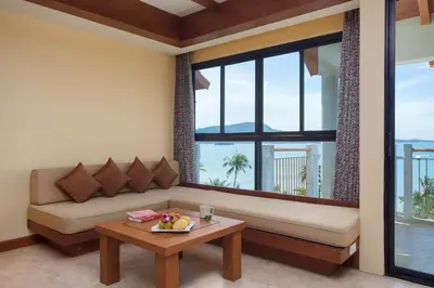 a living room with a couch and a table at By The Sea in Panwa Beach